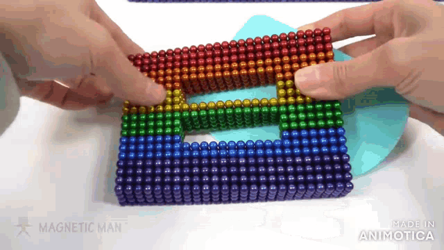 a person is playing with a rainbow colored magnetic man game