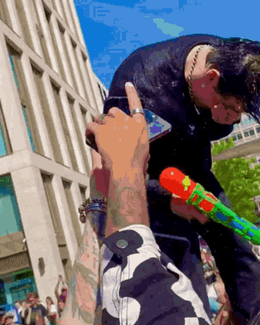 a woman is being sprayed with water while another person takes a picture