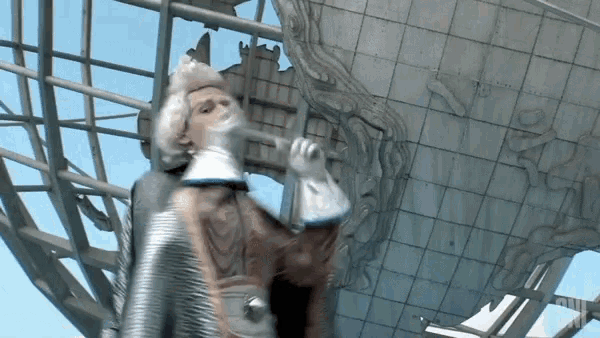 a man in a costume is standing in front of a statue of a globe