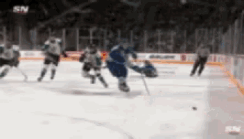 a hockey game is being played in front of a banner for bauer