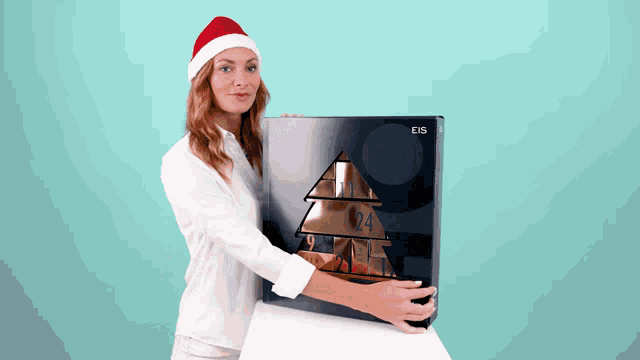 a woman wearing a santa hat is holding a box with the number 24 on it