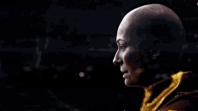 a woman with a bald head is talking to a man in a yellow jacket .