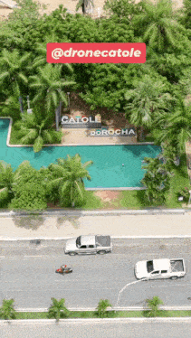an aerial view of a swimming pool with a sign that says @dronecatole