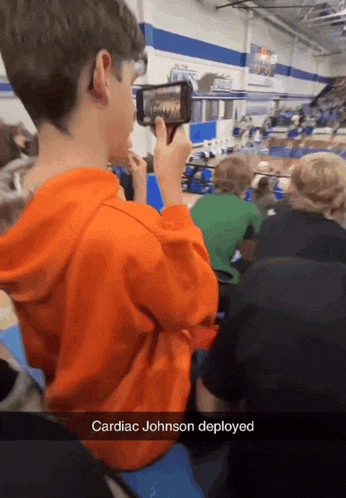 a boy taking a picture of a cardiac johnson deployed in a gym