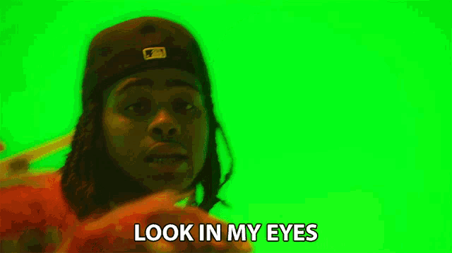 a man with dreadlocks and a hat says look in my eyes