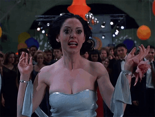a woman in a white dress is standing in front of a crowd of people