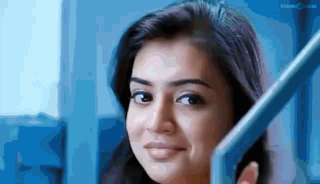 a close up of a woman 's face with a blue railing behind her