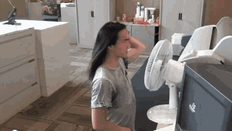 a man with long hair stands in front of a fan that says hp
