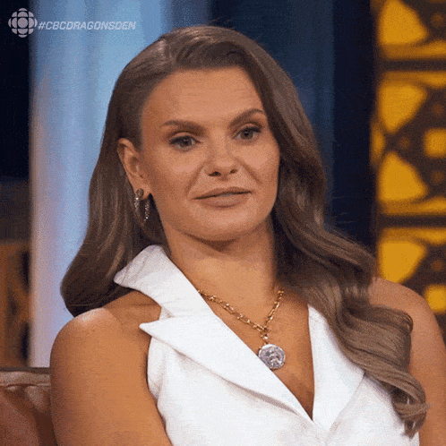 a woman sitting on a couch with the hashtag #cbcdragonsden on her face