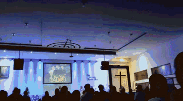 a large group of people are gathered in a church with a large screen that says jesus is lord