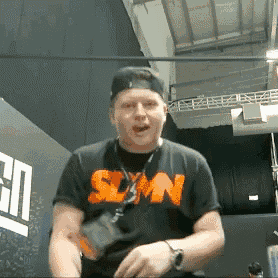 a man wearing a black shirt that says slyn on it