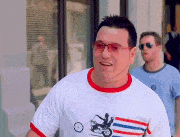 a man wearing a white shirt with a picture of a man on a motorcycle on it