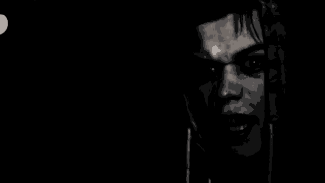 a black and white photo of a man 's face in a dark room