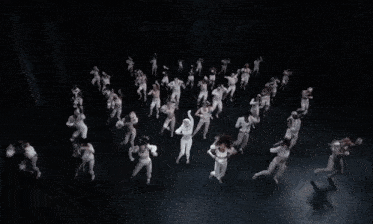 a woman in a white corset is dancing in front of a group of people