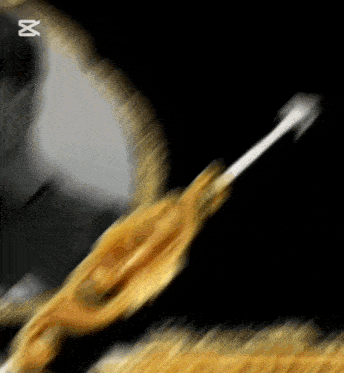 a blurred image of a gold object with the letter m on the bottom right
