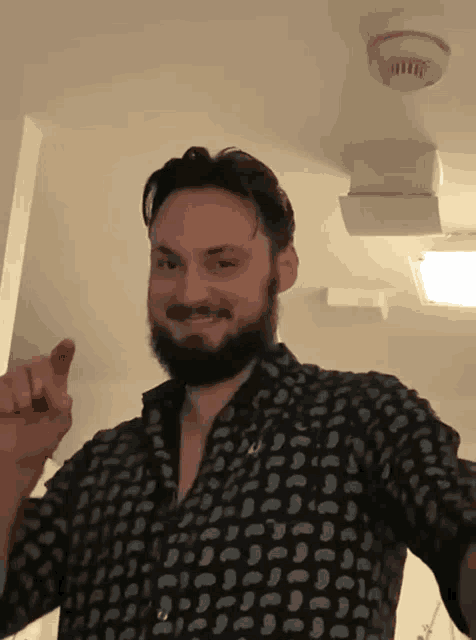 a man with a beard wearing a black shirt with white polka dots