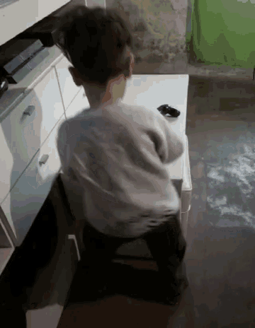 a young boy is sitting on a stool in front of a desk with a ps4 on it