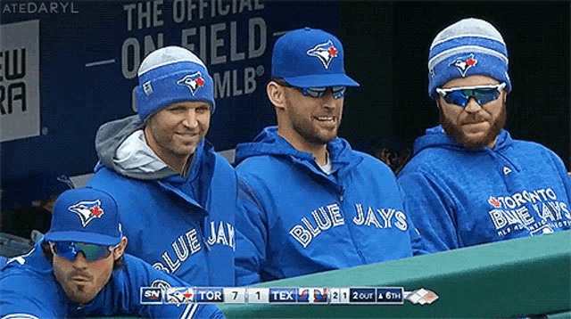 a group of blue jays players are sitting in a dugout