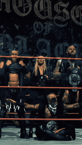 a group of wrestlers in a ring with the word house on the wall