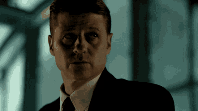 a man in a suit and tie is looking at something