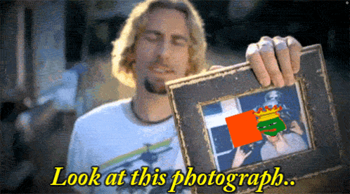 a man is holding a picture frame with the words look at this photograph