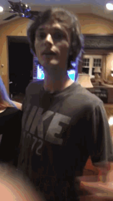 a man wearing a nike shirt is standing in a room