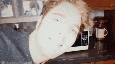 a man is taking a picture of himself in front of a microwave in a kitchen ..