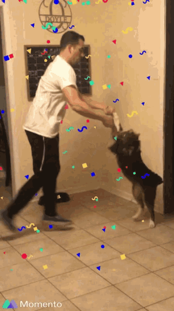 a man playing with a dog in front of a sign that says royce on it