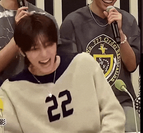 a man wearing a number 22 sweatshirt is laughing
