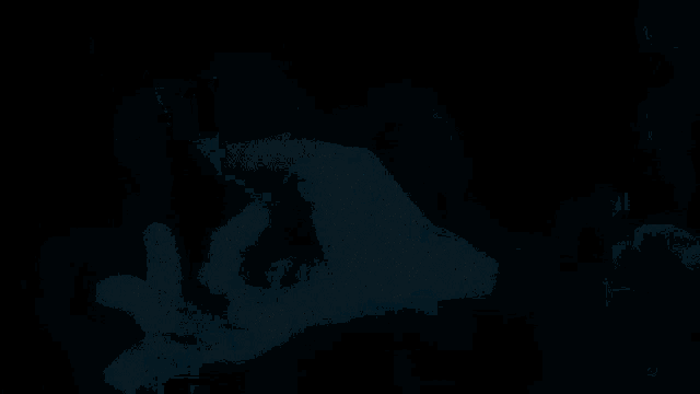 a person 's hand is reaching out into a dark blue background