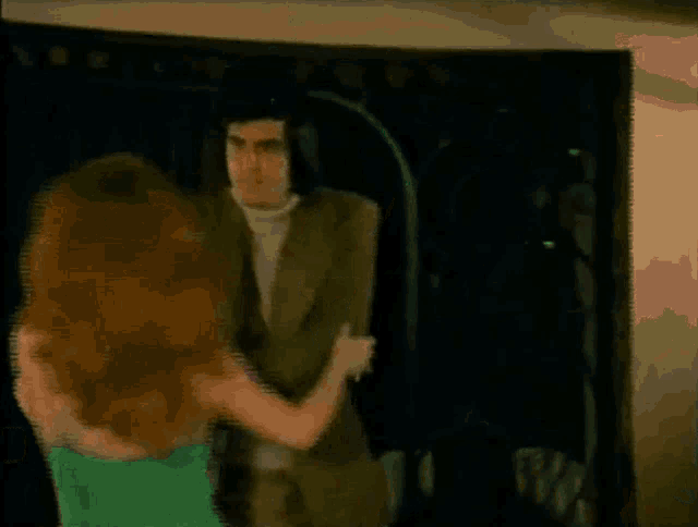 a woman in a green dress is dancing with her arms in the air