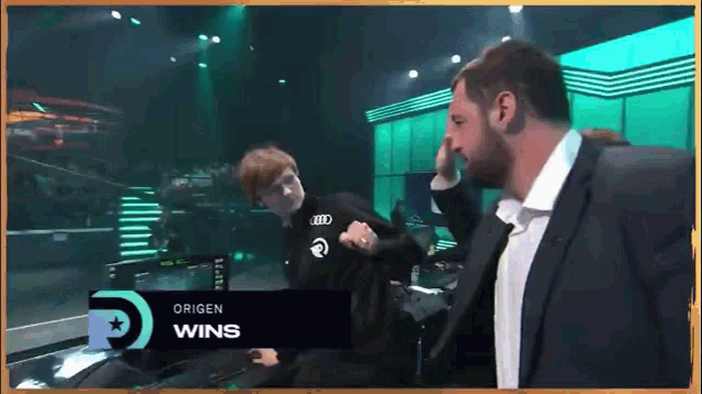 a man in a suit is standing in front of a sign that says " origen wins "