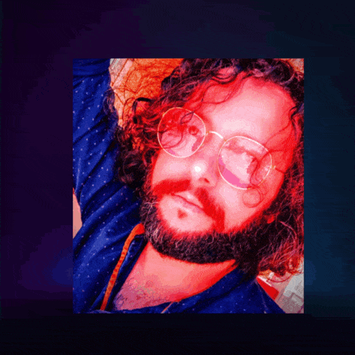 a man with glasses and a beard is laying down