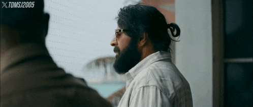 a man with a beard is wearing sunglasses and a ponytail ..