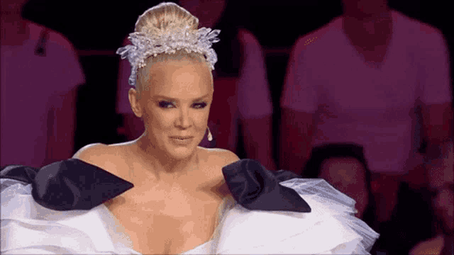 a woman in a white and black dress with a crown on her head .