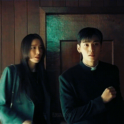 a man and a woman are standing next to each other and the man is wearing a priest 's robe