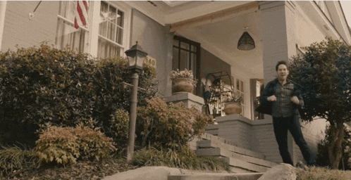 a man standing on the steps of a house with a sign that says ' aa '
