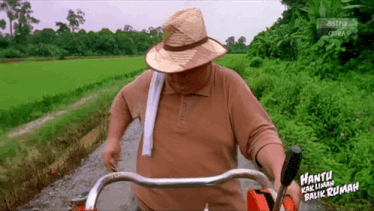 a man in a straw hat is driving a tractor with the words hantu kalimah balik rumah written on the side