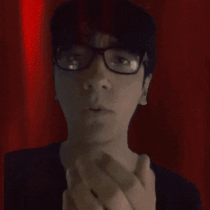 a man wearing glasses and a black shirt is making a face