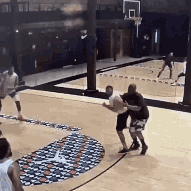 a group of men are playing basketball on a court with a converse logo on the floor