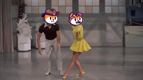 a man and a woman are dancing on a stage with cartoon faces on their heads .