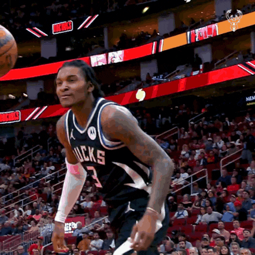 a basketball player wearing a bucks jersey is about to shoot the ball