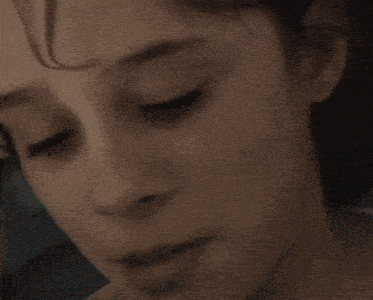 a close up of a woman 's face with her eyes closed and her mouth open .
