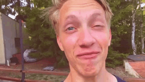a young man is making a funny face while making a funny face .