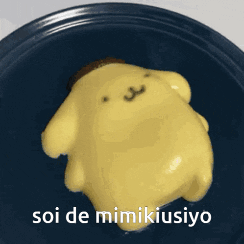 a blue plate with a yellow stuffed animal on it that says soi de mimikiusiyo