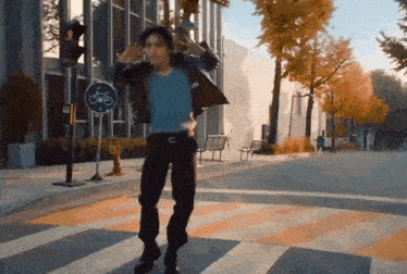 a man in a leather jacket is dancing in front of a bicycle sign