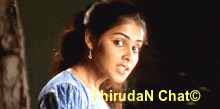 a woman in a blue shirt is standing in front of a sign that says thirdan chat