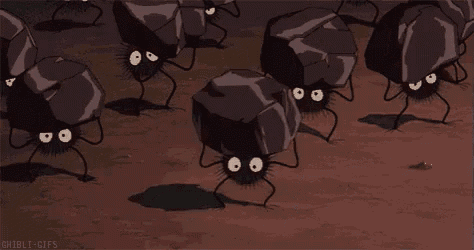 a group of cartoon spiders are crawling on rocks in a field .