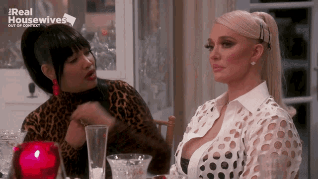 two women are sitting at a table with the words real housewives out of context on the top