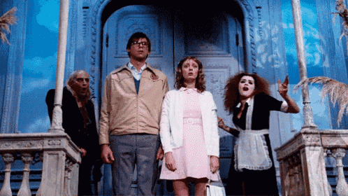 a group of people are standing in front of a door and one of them is wearing a jacket with the letter o on it